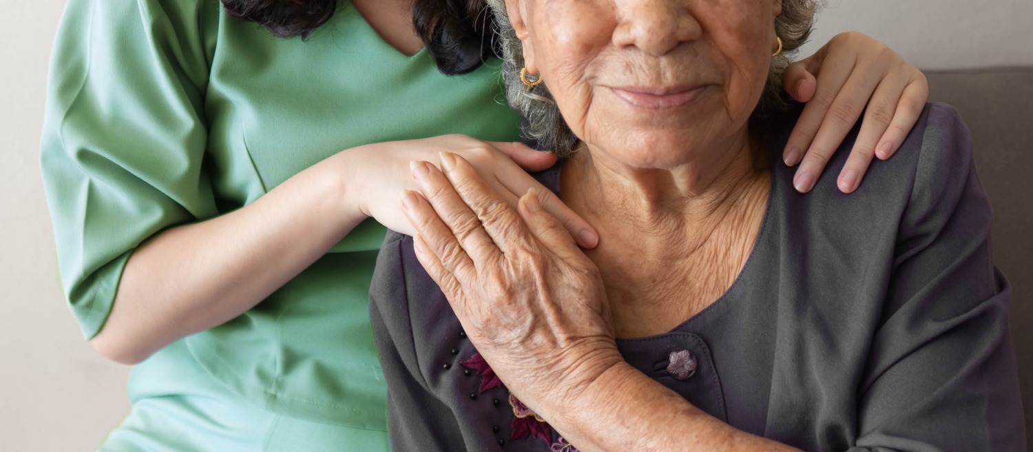 mature woman and caregiver touching hands