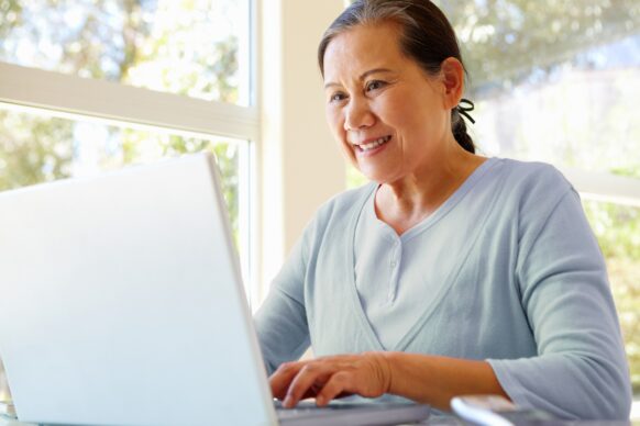 elderly woman typing on laptop