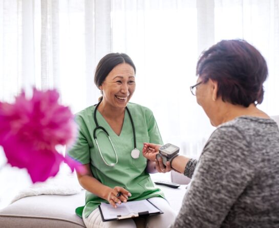 Female nurse measuring heart rate to senior patient