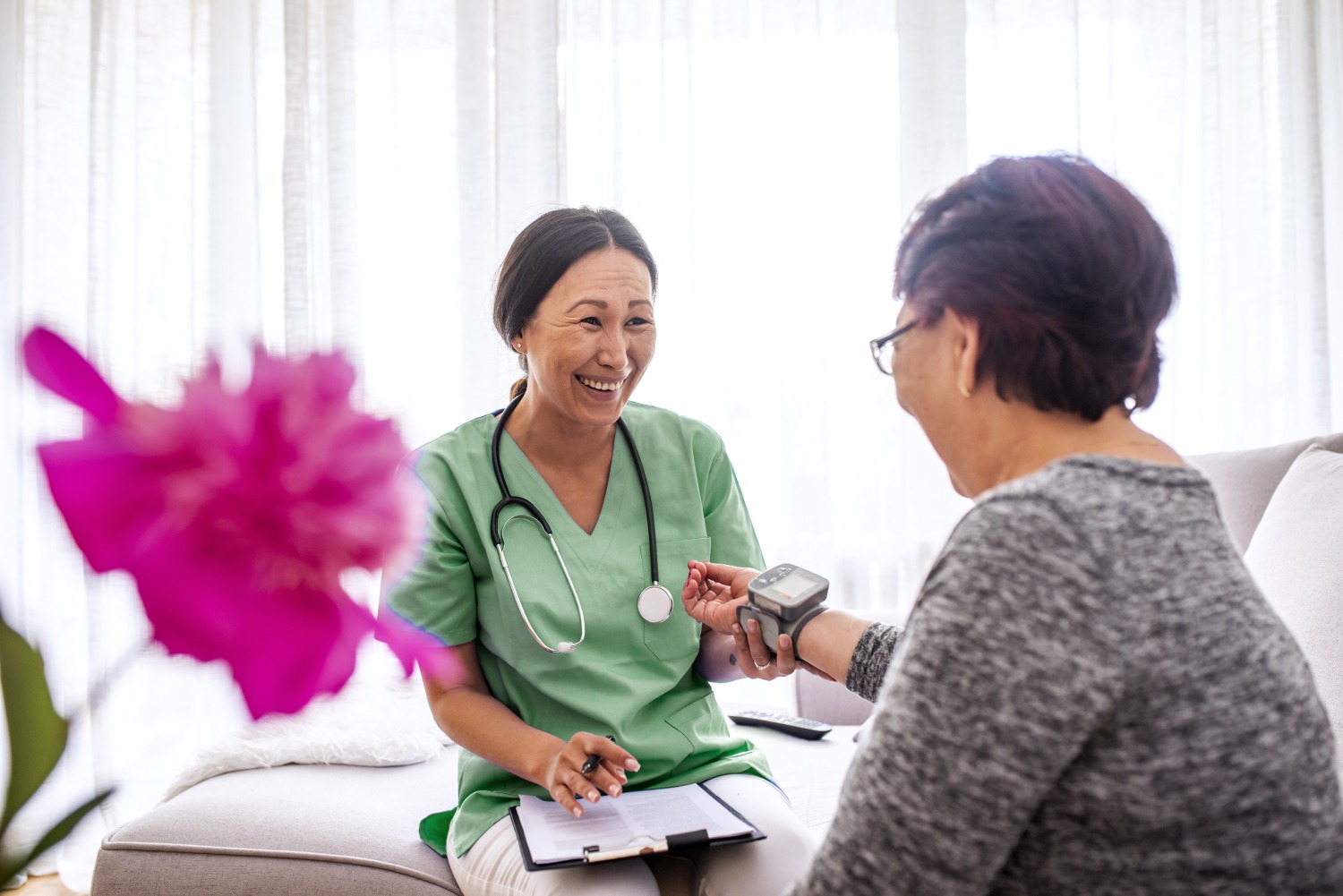 Female nurse measuring heart rate to senior patient