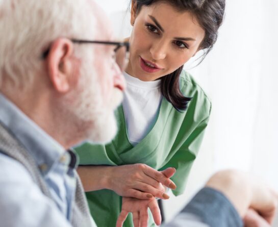 Healthcare professional talking with senior male wearing glasses