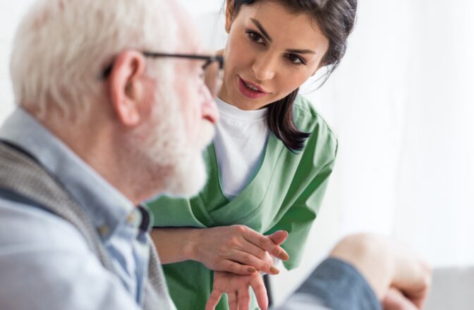 Healthcare professional talking with senior male wearing glasses