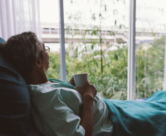 elderly person looking out window
