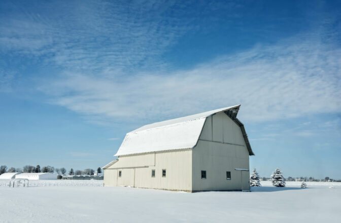 white barn in field in winter