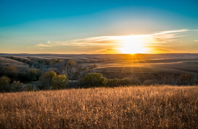 view of hilly prairie landscape at sunset