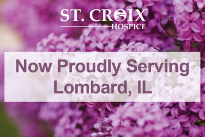 Text informing that St. Croix Hospice now serves Lombard with purple flowers in the background