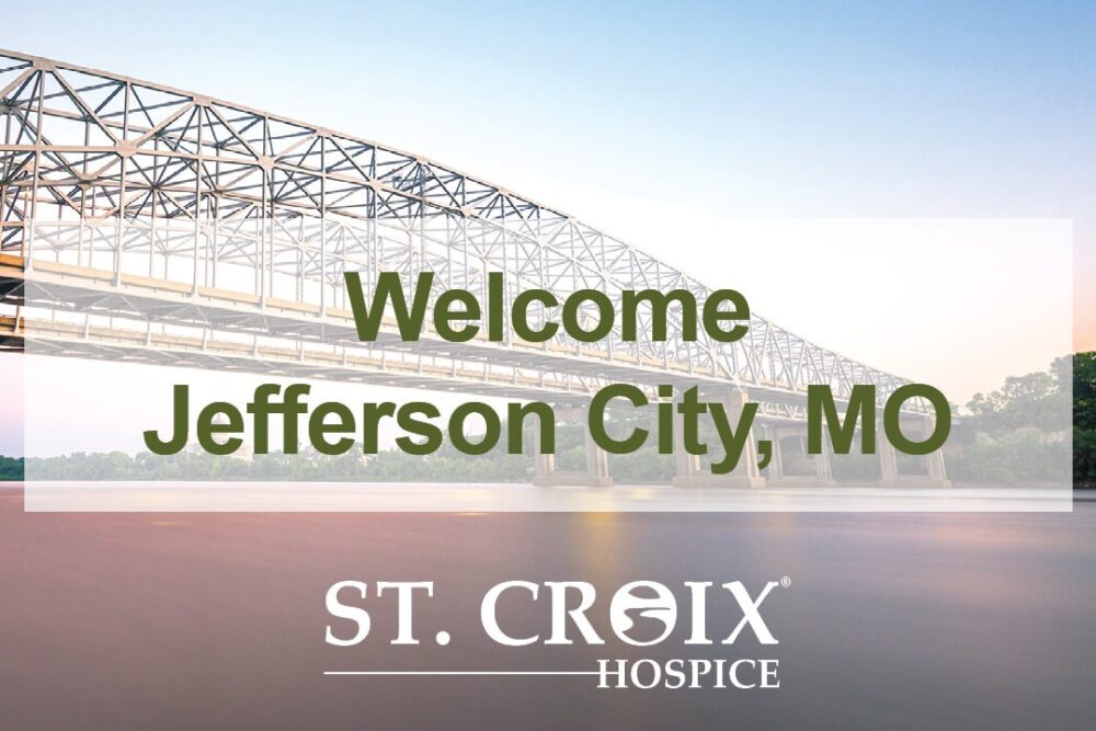 Welcoming text with a city bridge crossing Missouri river on the background