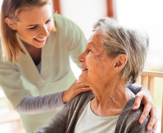 Young nurse caring for senior female patient