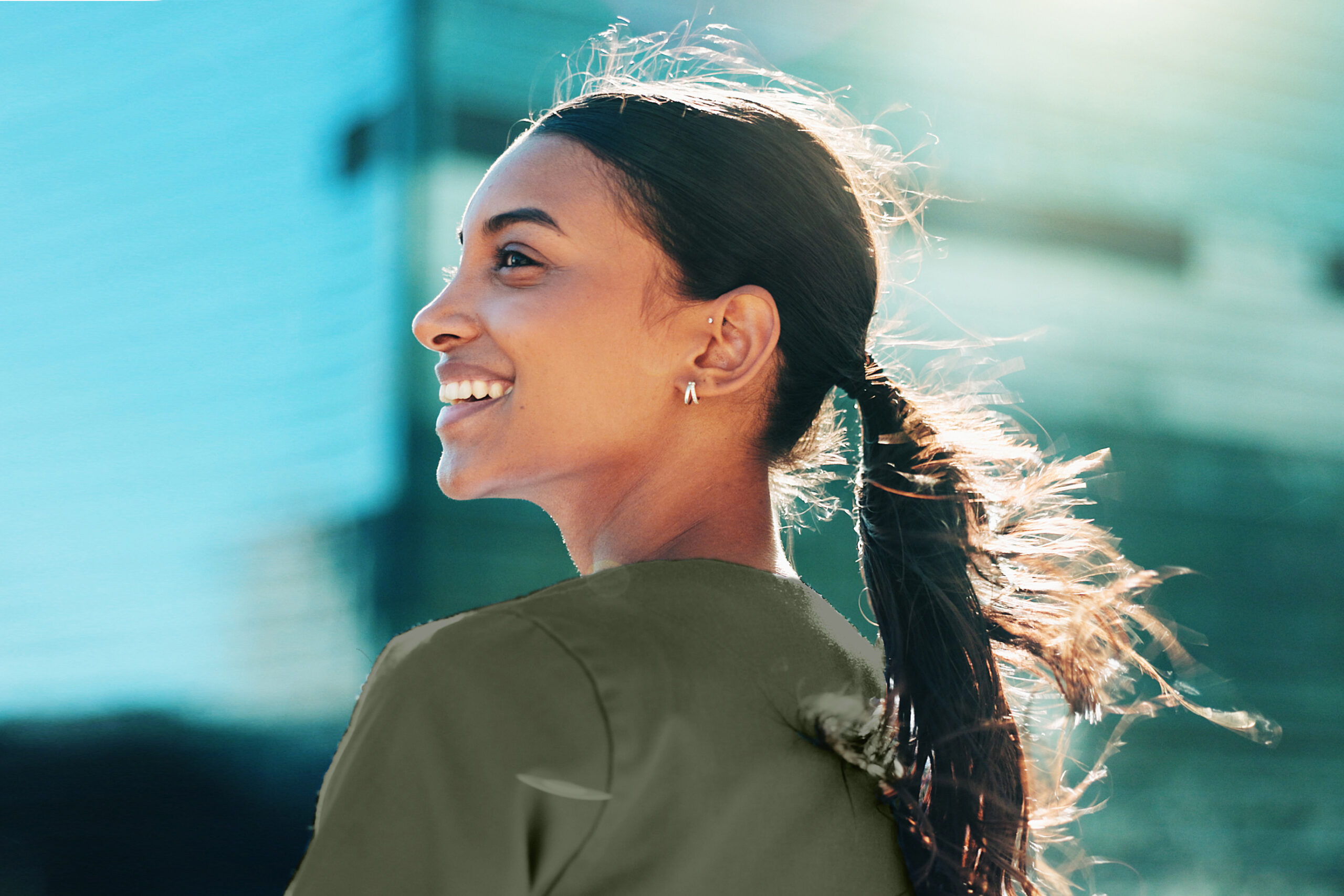 nurse with long dark hair in a pony tail smiling