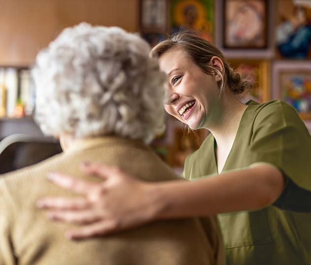 nurse smiling and wrapping arm around patient