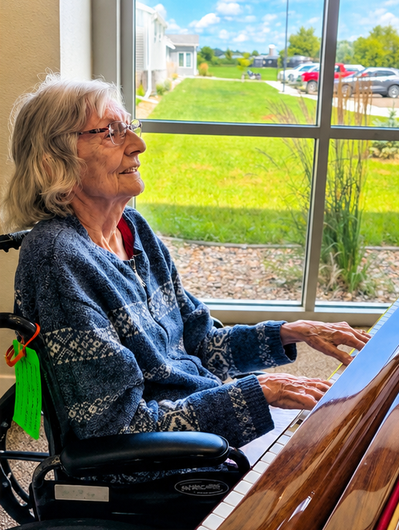 senior woman in wheelchair playing piano in front of window